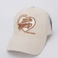 Gros plan sur la broderie de cœur et le lettrage d'une casquette de baseball en coton beige - Taille Enfant / Beige
