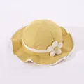 Detailed macro view of yellow baby sun hat with white lace trim and floral embellishment - Toddler One Size / Yellow