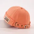Gros plan du bonnet orange en coton avec écusson en cuir et boucle métallique de réglage - 50-52CM / Orange