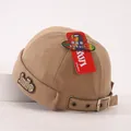 Detailed close-up of khaki docker hat with smile patch and adjustable metal buckle strap - Baby 2-6 Years 50-52CM / Khaki
