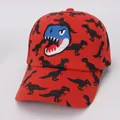 Detail van rode katoenen kinderpet met blauwe dinosaurus borduring en dinoprint - Kinderen 3-10 Jaar (50-54CM) / Rood