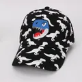 Detailopname van kinderpet met cartoon dinosaurus borduursel en all-over dinoprint - Kinderen 3-10 Jaar (50-54CM) / Zwart