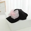 Detail of a black baseball cap with a large pink mesh bow and white pearl embellishments - Kids Size / Black