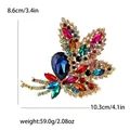 Luxurious multi-color crystal leaf brooch with large blue teardrop stone in gold finish - Colorful