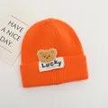 Dettaglio della maglia del cappello arancione con orsetto e etichetta Lucky cucita - Bambini 2-6 Anni Elastico / Arancione