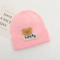 Dettaglio del berretto rosa in maglia per neonati con patch orsetto e etichetta Lucky - Bambini 2-6 Anni Elastico / Rosa
