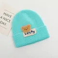 Dettaglio del cappello in maglia a coste turchese per neonati con orsetto e etichetta Lucky - Bambini 2-6 Anni Elastico / Blu Lago