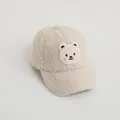 Dettaglio del cappellino beige in pile agnellato con toppa ricamata a forma di orso - Taglia Unica Bambini / Beige