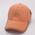 Detailopname van een lichtoranje katoenen baseballpet met borduursel en bruine bies - 48-54CM / Oranje