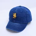 Détail de la casquette bébé en jean bleu avec patch de dessin animé jaune et texture - 47-50cm / Bleu foncé