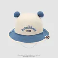 Dettaglio cappello pescatore per neonati in cotone con orecchie blu e ricamo Kukuji - 48-50cm / Blu