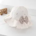 Detailed macro view of cream cotton sun hat with brown bow tie patterns and mesh detail - 52-54cm / Beige