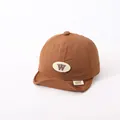 Brown soft brim baby baseball cap featuring a white oval patch with a dark brown W letter - Letter W Style / Coffee (Letter W)