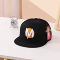 Detailansicht der schwarzen Kinder-Hip-Hop-Mütze mit M-Stickerei und originalen Etiketten - Kinder ca. 3-10 Jahre / Schwarz