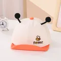 Detalle de gorra de malla de verano para bebé con bordado de abeja y pompones decorativos - Naranja