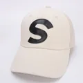 Close-up of beige mesh baseball cap featuring a black leather S letter patch and brim stitching - Kids 50-54cm / Beige