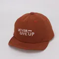 Detalle de gorra infantil de pana marrón con bordado blanco NEVER GIVE UP - 45-48 cm / Café