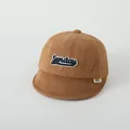 Détail de la broderie Sunday sur la casquette bébé en velours côtelé caramel - Bébé Bambin / Café Foncé