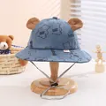 Detail of blue corduroy baby bucket hat with plush bear ears and adjustable chin strap - Blue