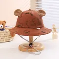 Close-up of brown corduroy baby bucket hat with cute bear ears and adjustable chin strap - Coffee