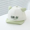 Detail van babyhonkbalpet met zachte rand, schattig kikkermotief en 3D-oren ontwerp - Kikker Stijl / Bleekgroen
