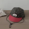 Close-up of leopard print baseball cap with red flat brim and OKAY embroidered patch - OKAY Embroidery Style / Wine Red Trim