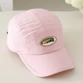 Detailopname van roze 5-panel kinderpet met HONG-letterpatch en een gebogen klep - Roze