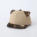 Detailed close-up of khaki baby baseball cap featuring leopard print ears and logo tag - Adjustable / Khaki
