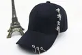 Detail einer schwarzen Baumwoll-Cap mit silbernen Metallringen und seitlicher Kette - Kinder / Mehrere Metallringe Mit Seitenkette / Schwarz