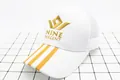 Détail de casquette baseball en filet blanc et bord jaune avec broderie Nine Percent - Enfants (2-8 ans) / Blanc Or