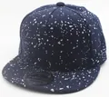 Detail view of a navy blue snapback cap with white paint splatter and sport sticker - Navy Blue