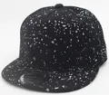 Detail einer schwarzen Snapback-Kappe mit silbernem Farbspritzer-Muster und flachem Schirm - Schwarz