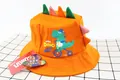 Detail of orange kids sun hat featuring 3D dinosaur spines and cartoon dino print - Kids (2-6 Years) / Orange