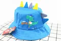 Close-up of blue cotton bucket hat for kids with cartoon dinosaur pattern and 3D fin details - Kids (2-6 Years) / Blue
