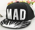 Detalle del bordado MAD y diseño de salpicaduras de pintura en gorra negra plana - Negro + Negro