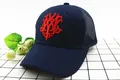 Dettaglio del cappellino navy con rete e ricamo rosso 3D su sfondo a quadretti decorato - Stile Mesh Blu Notte
