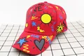 Detail view of the colorful letter graffiti and sun prints on a red kids baseball cap - Kids (3-12 Years) / Red Sun