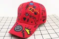 Detail of red baseball cap with graffiti prints like BE YOURSELF and ARE LOVED - Kids (3-12 Years) / Smiley Red
