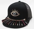 Detail of flat brim baseball cap featuring a golden evil eye and colorful metal charms - Mesh Style / Black Evil Eye