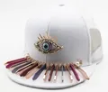 Detail of white mesh trucker hat featuring metal devil eye and colorful bar pendants - Mesh Style / White Evil Eye