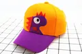 Dettaglio del cappellino da baseball per bambini arancione e viola con ricamo dinosauro - Bambini (2-8 anni) / Arancione