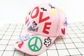 Close-up of pink cotton baseball cap featuring colorful LOVE and Peace graffiti prints - LOVE Heart Style / Pink