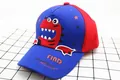 Close-up of red dinosaur embroidery and FIND Dinosaurs text on navy kids baseball cap - Children (2-8 Years Old) / Royal Blue Red Patchwork