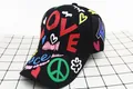 Detail of a kids black baseball cap featuring colorful LOVE and Peace graffiti prints - LOVE Heart Style / Black
