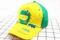 Close-up of kids yellow baseball cap with green dinosaur embroidery and cotton texture - Children (2-8 Years Old) / Yellow Green Patchwork