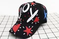 Dettaglio di un cappello nero con stampa graffiti JOY, icona a cuore e scritte laterali - Bambini (3-12 anni) / Stile JOY / Nero