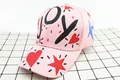 Dettaglio del berretto da baseball rosa in cotone con graffiti JOY e cuori rossi - Bambini (3-12 anni) / Stile JOY / Rosa
