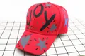 Dettaglio del cappellino rosso in cotone con lettere JOY e motivi a cuore e stella - Bambini (3-12 anni) / Stile JOY / Rosso