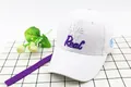 Detail of white cotton baseball cap featuring 3D text embroidery and long purple strap - Kids (48-53cm) / White