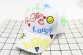 Dettaglio cappellino bianco con scritte graffiti colorate LOVE e SMILE stampate sopra - Bambini (3-10 Anni) / Stile LOVE Sole / Bianco
